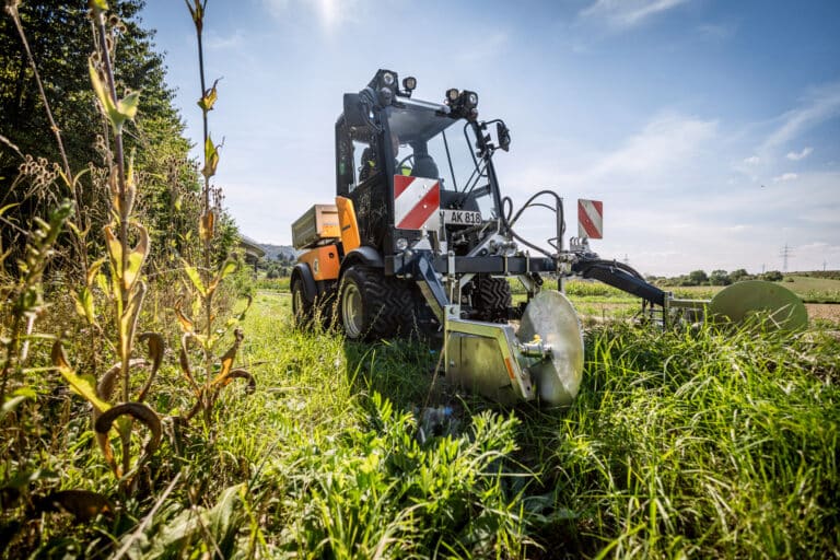 Karcher Holder C 70 Municipal tractor mowing greenery in a field