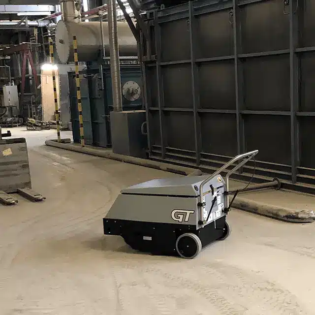 Tomcat GT industrial sweeper cleaning up dust in a factory