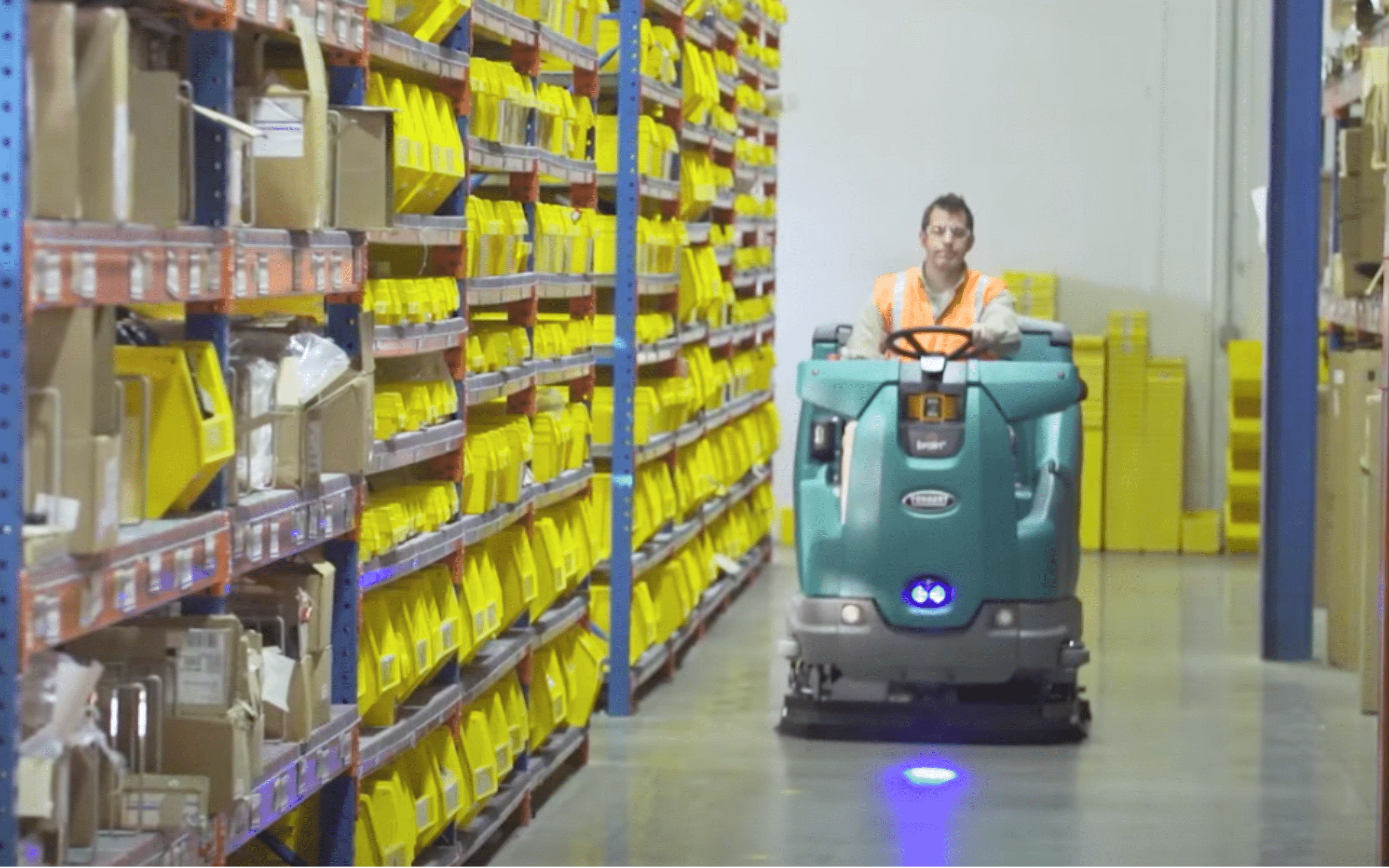 commercial floor scrubbing machine in industrial warehouse